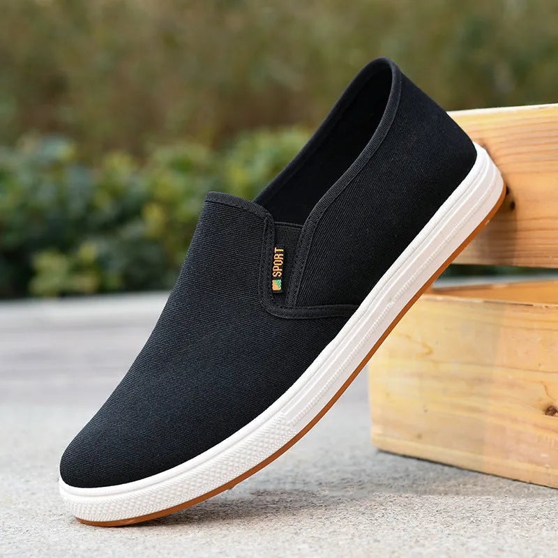 Men's black and blue slip-on canvas shoes with composite soles showing round toe design