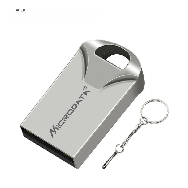 Silver car-shaped metal USB flash drive on a chain, shown next to a laptop.