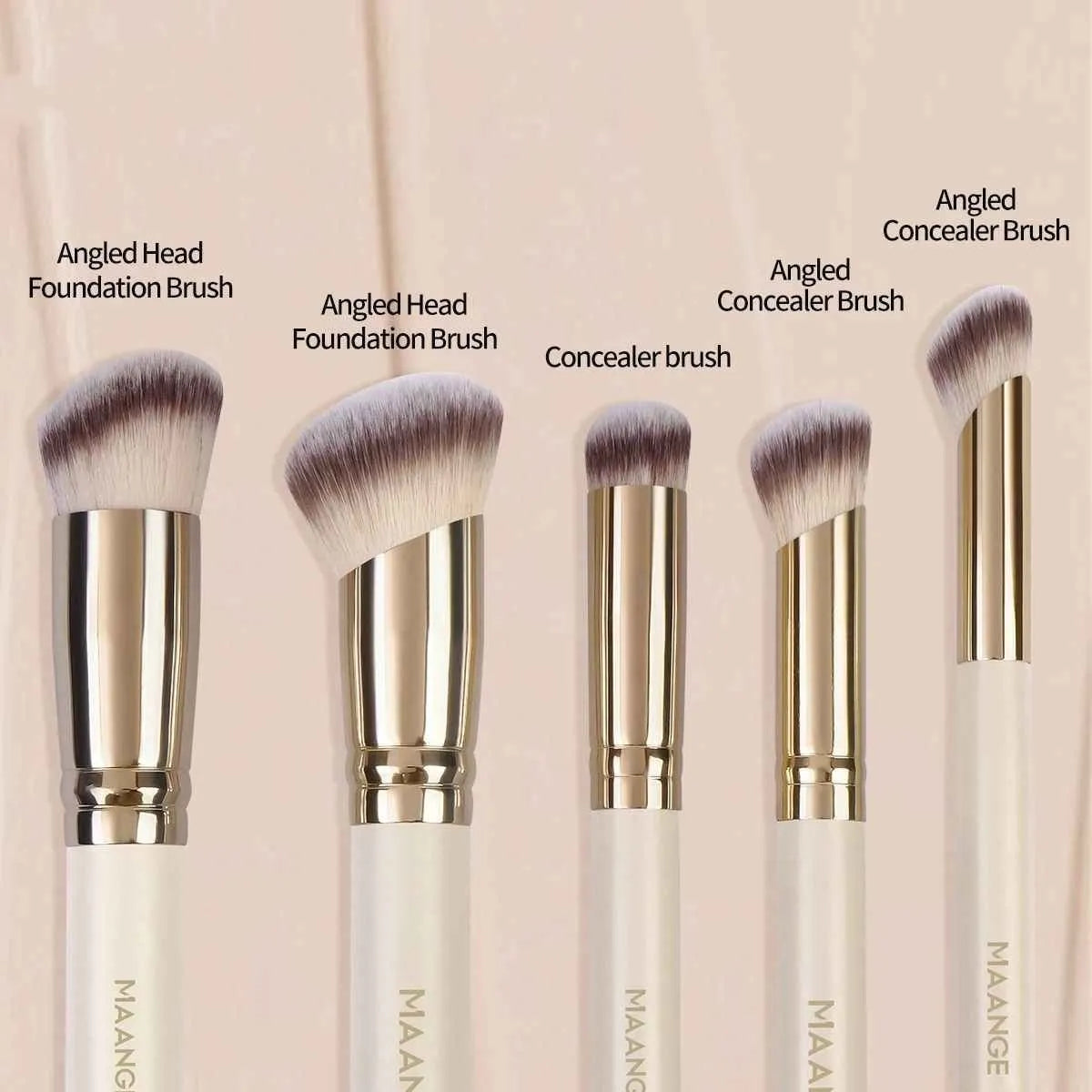 Angled apricot blusher brush and four other synthetic makeup brushes on a white surface.