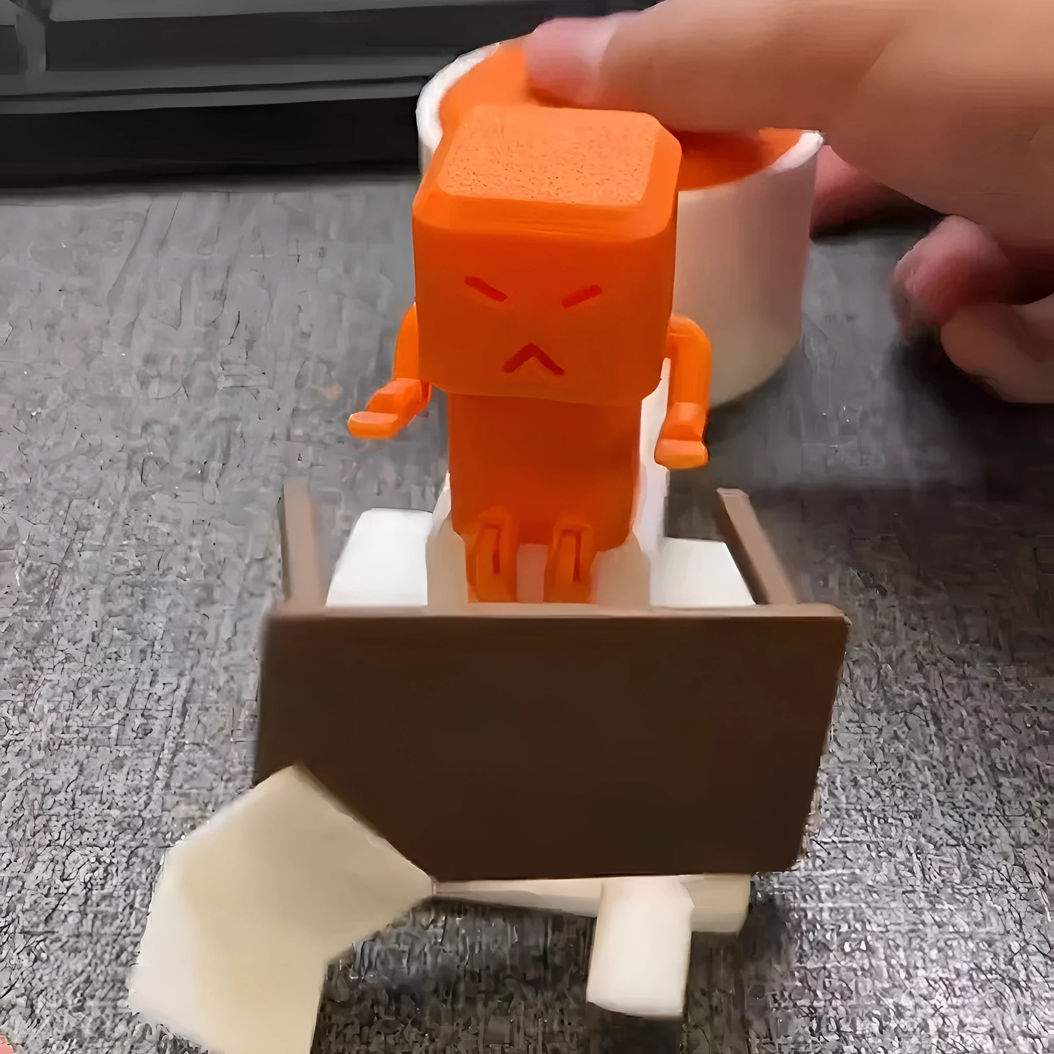 Orange plastic vent-themed table spinning decompression fidget toy on a desk.