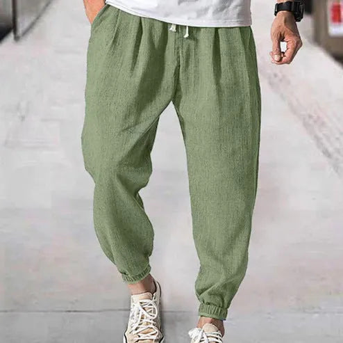 Men's cotton ankle banded trousers in light green colour showing loose fit and summer casual styling