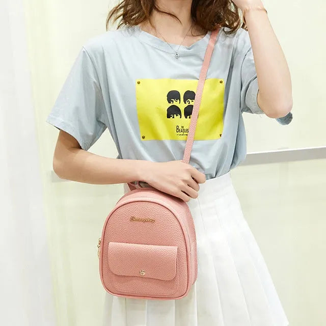 Women's compact black PU bag worn as both a shoulder bag and a small backpack.