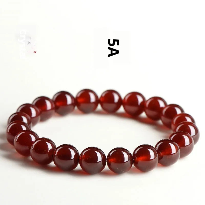 Natural orange red garnet ball crystal bracelet with traditional ruyi design elements on wrist