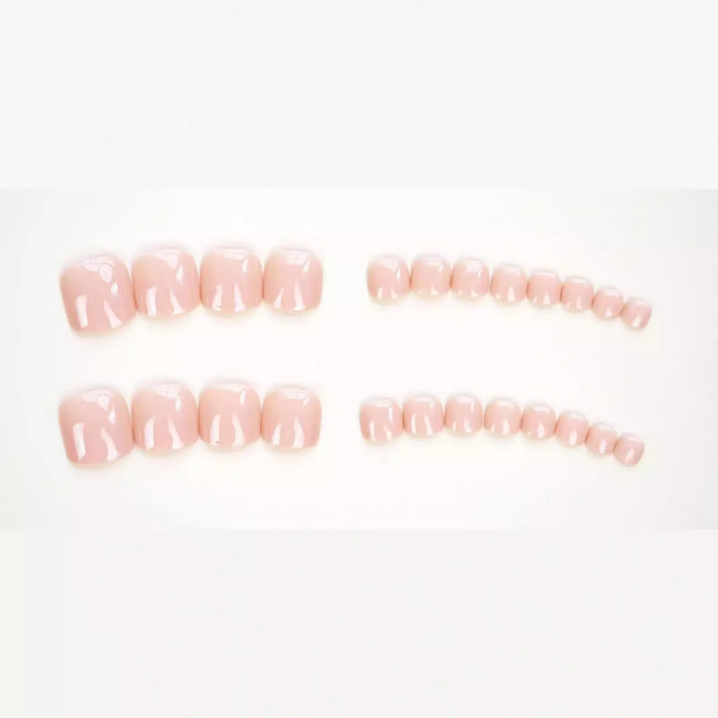 Set of plastic skin-coloured glue-on toe nail stickers with adhesive.