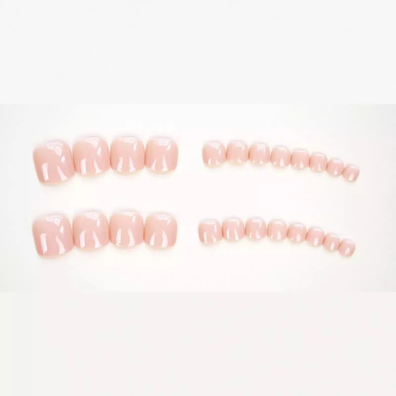 Set of plastic skin-coloured glue-on toe nail stickers with adhesive.