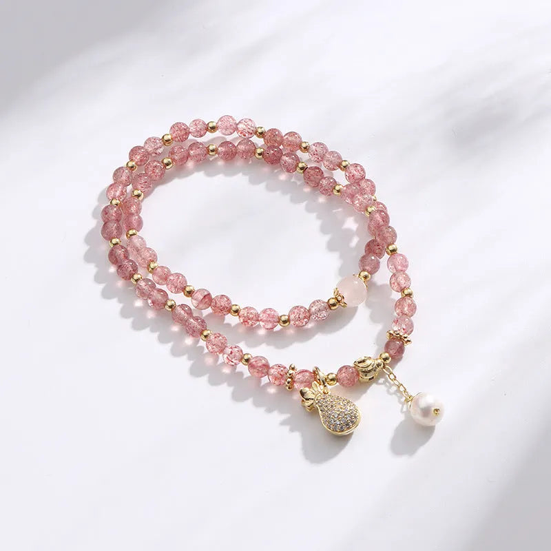 Geometric strawberry quartz crystal bracelet for women on a wrist.