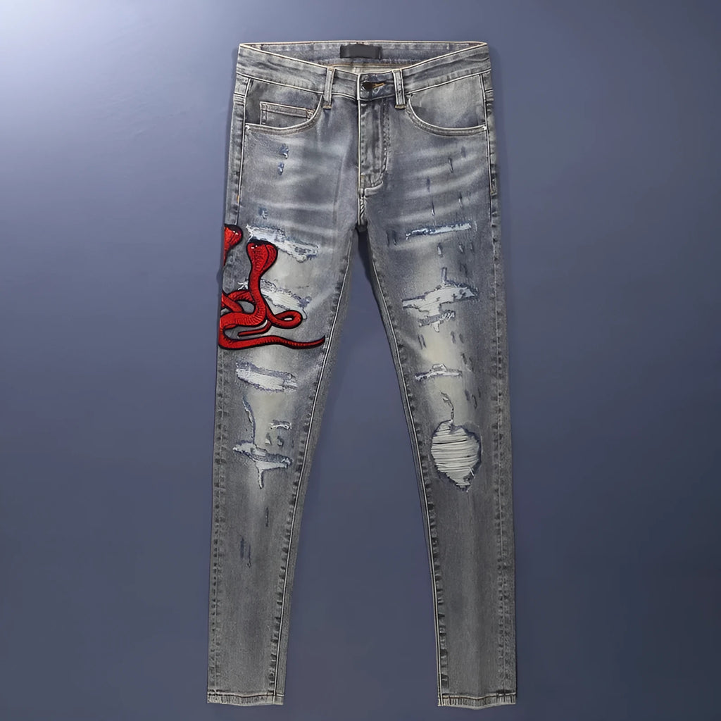 Distressed slim fit jeans with embroidered hole patches in washed-out old colour