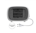 Compact green mini ceramic heater with metal mesh front on a wooden desk