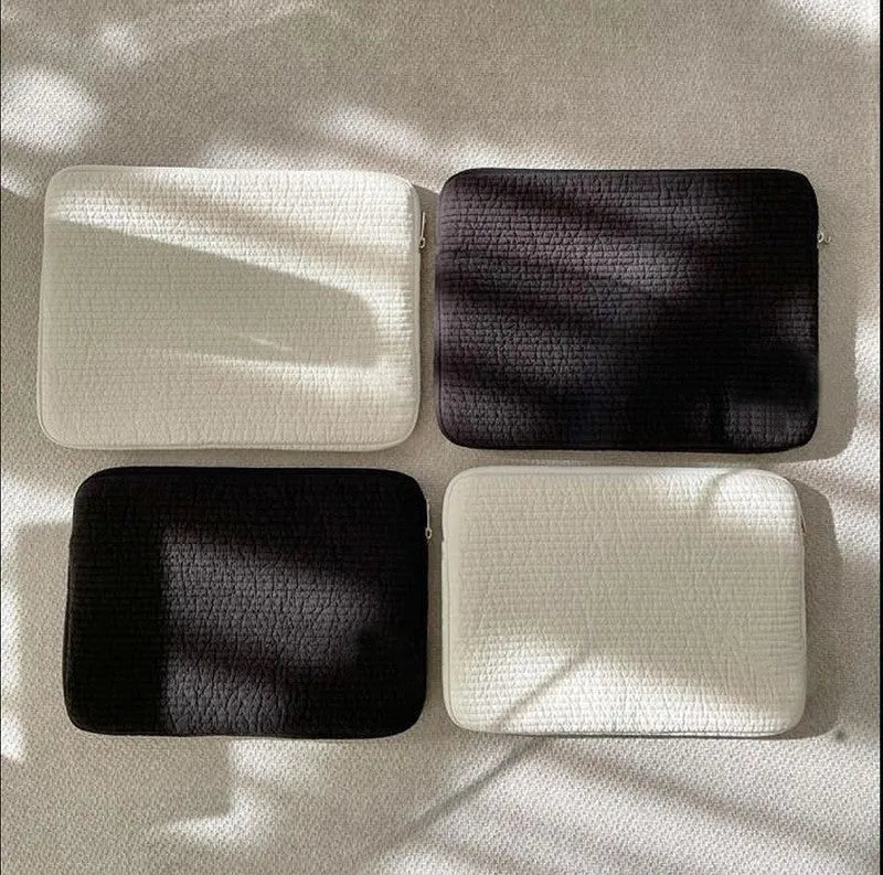 Black and white cotton cloth anti-seismic laptop bag in clutch style for 11-inch to 15.6-inch devices.
