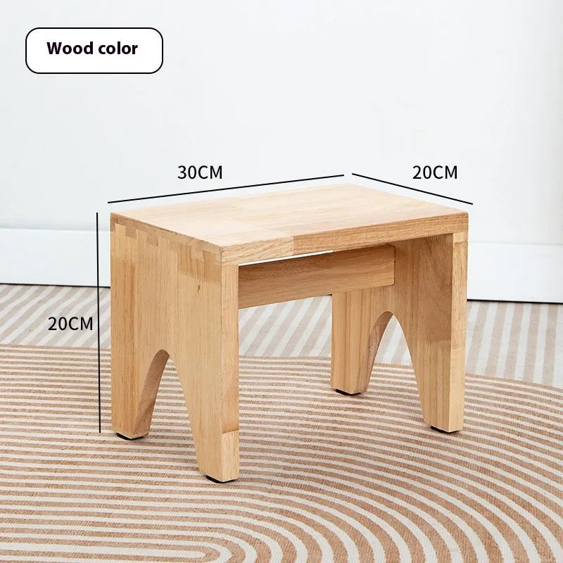 Solid wood shoe changing stool with a distressed rustic finish and sturdy bracket legs.