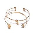 Gold women's vintage cuff bracelet with arrow knotted design on wrist