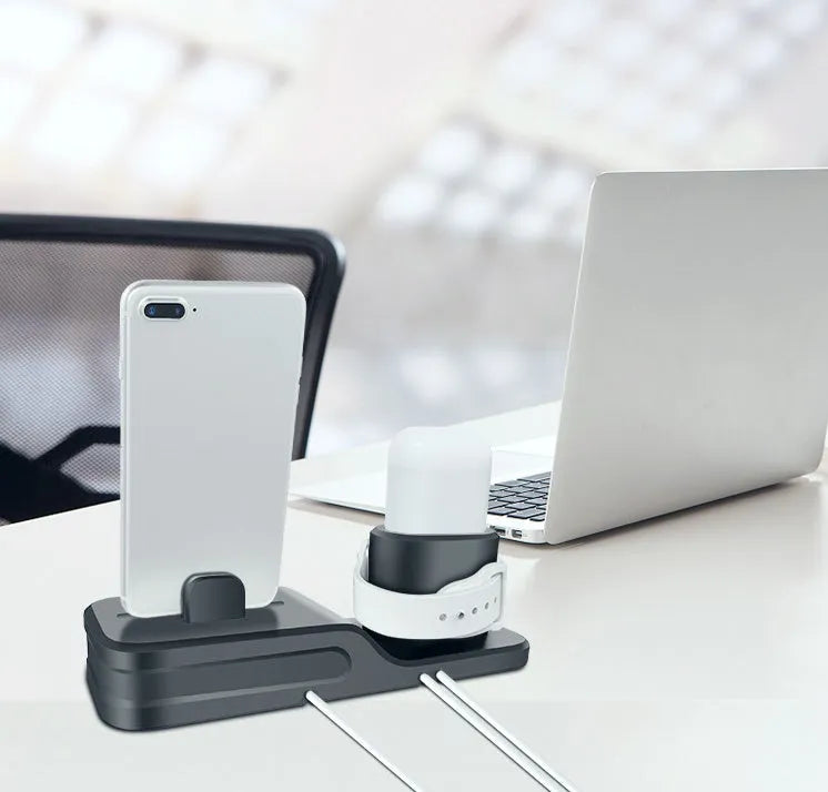 Black silicone 3-in-1 charging base for iPhone, iWatch, and AirPods on a plain surface