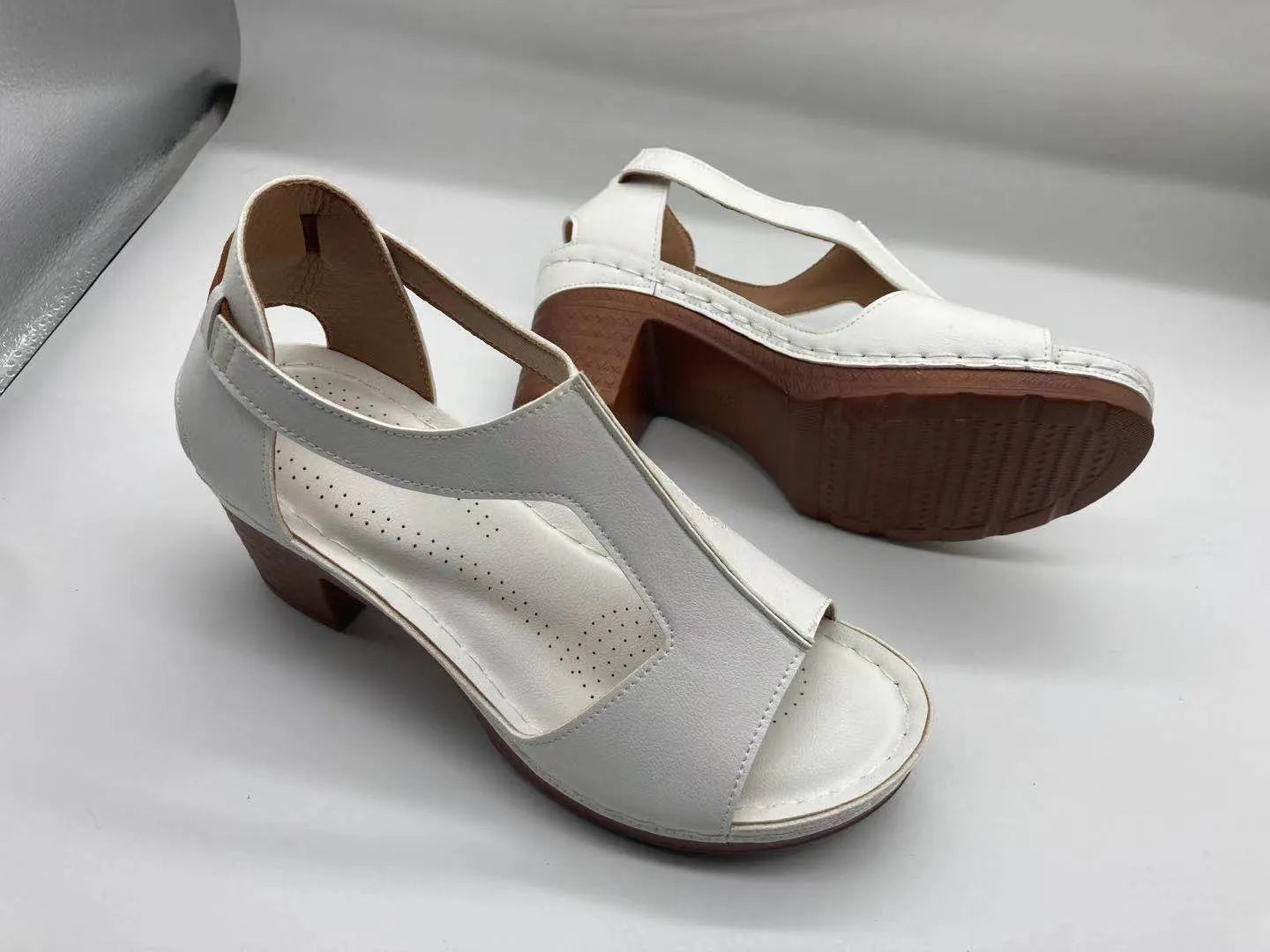 Women's peep toe wedge sandals with buckle detail, low heel, on a white background.