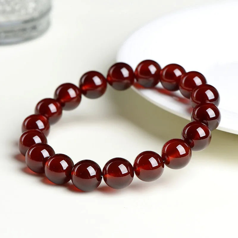 Natural orange red garnet ball crystal bracelet with traditional ruyi design elements on wrist