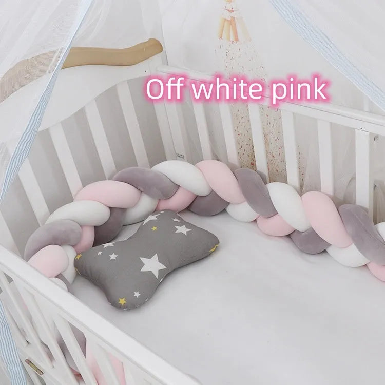 Braided knot crib bumper in spandex velvet, shown bending to fit a white wooden cot.