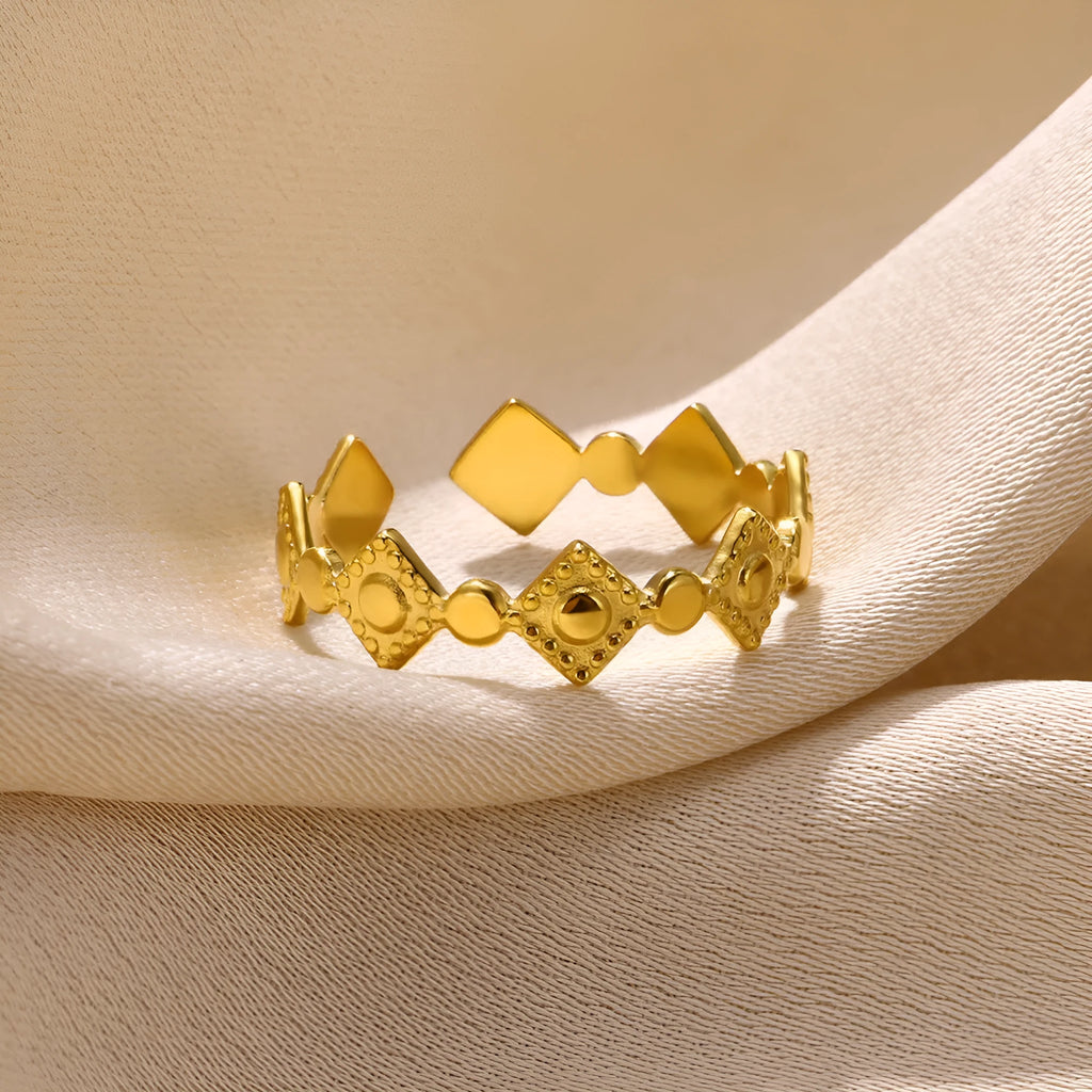 Geometric titanium steel women's ring with gold diamond finish on grey background