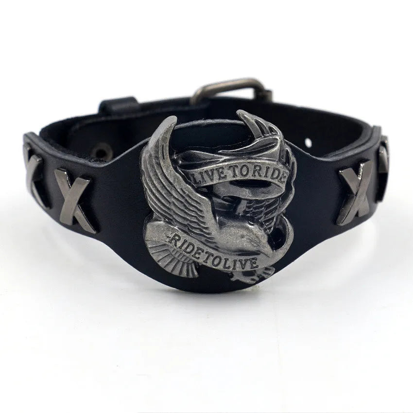 Black leather bracelet with an alloy eagle decoration and watch-button clasp on a wrist.
