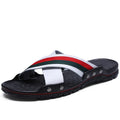 Men's white cowhide leather flip flops with a non-slip PU sole on a beach background.