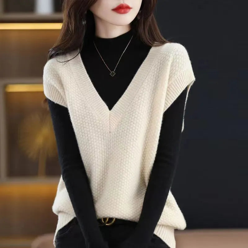 Women's creamy-white V-neck sleeveless knitted vest with a textured 3D pattern on a hanger.