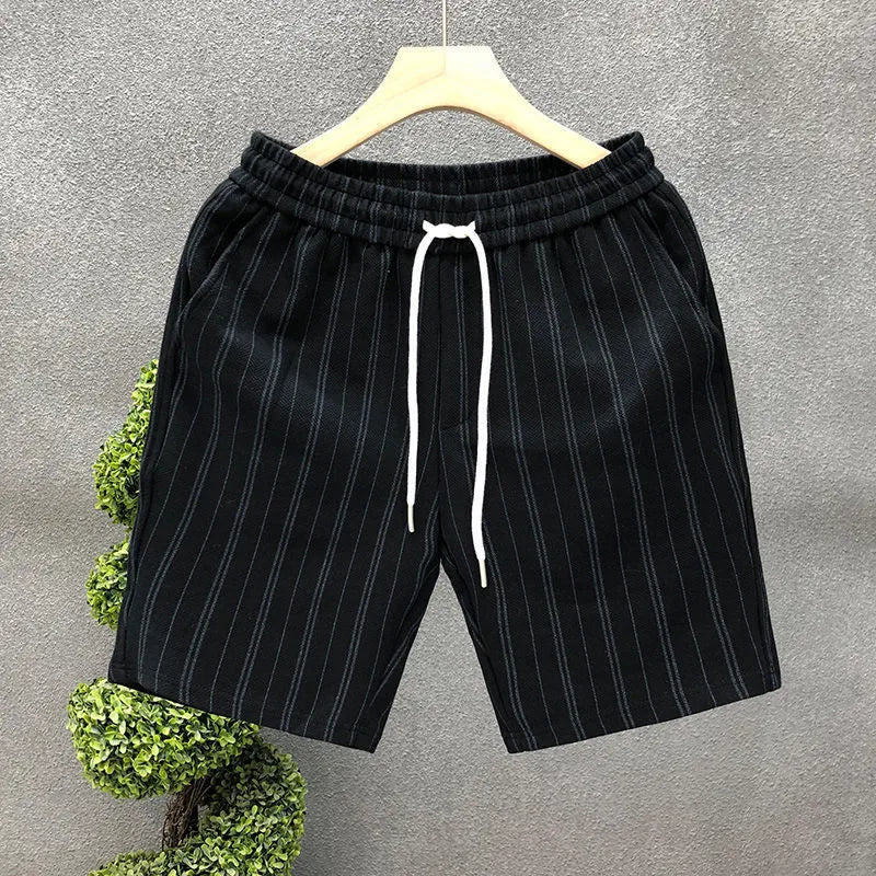 Men's black and white striped fleece-lined casual shorts with an elastic waistband on a grey background.