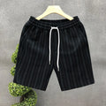 Men's black and white striped fleece-lined casual shorts with an elastic waistband on a grey background.