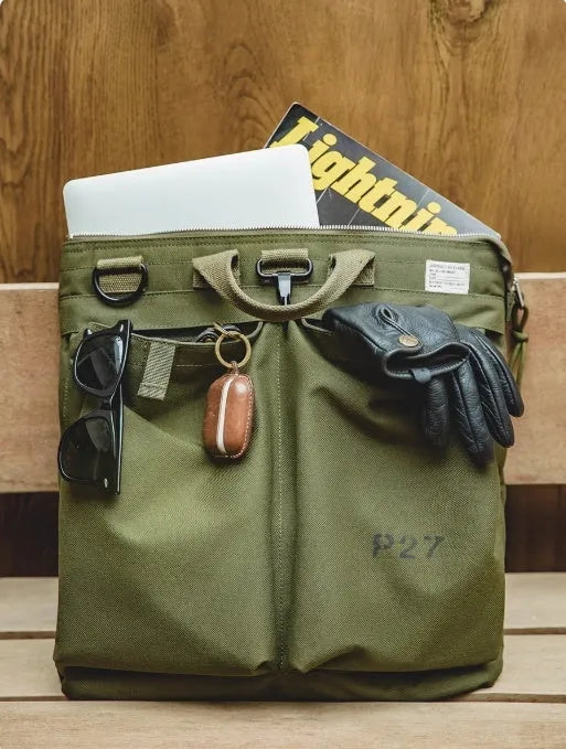 Medium canvas crossbody messenger bag in military green showing laptop compartment and shoulder strap