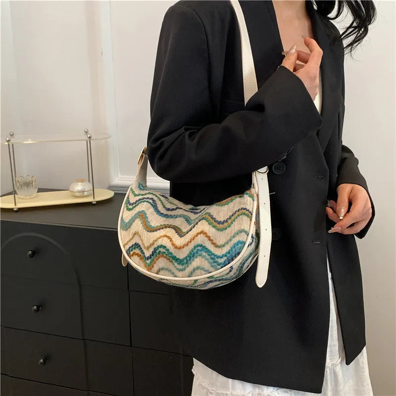 Women's knitted straw woven crossbody bag showing woven texture and internal phone compartment