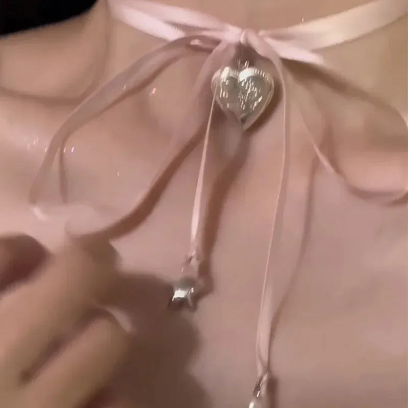 Close-up of a women's alloy love pendant necklace with electroplated finish on a clavicle chain.