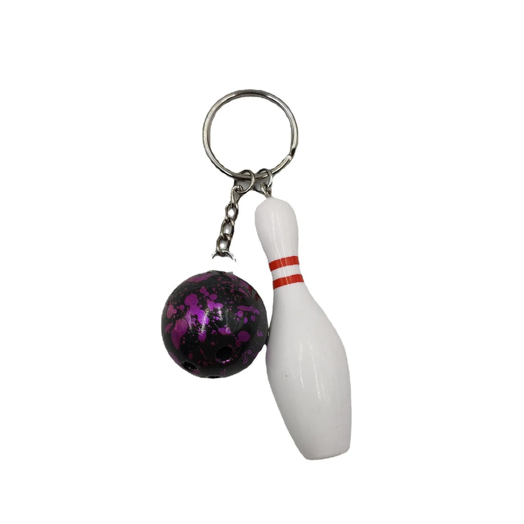 Miniature dark red bowling ball keychain on a metal key ring against a white background.