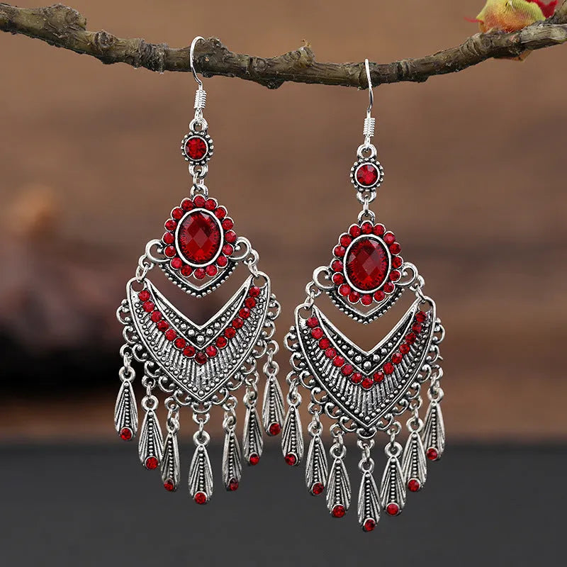 Purple drop-shaped earrings with long fringe detailing, showing retro ethnic style.
