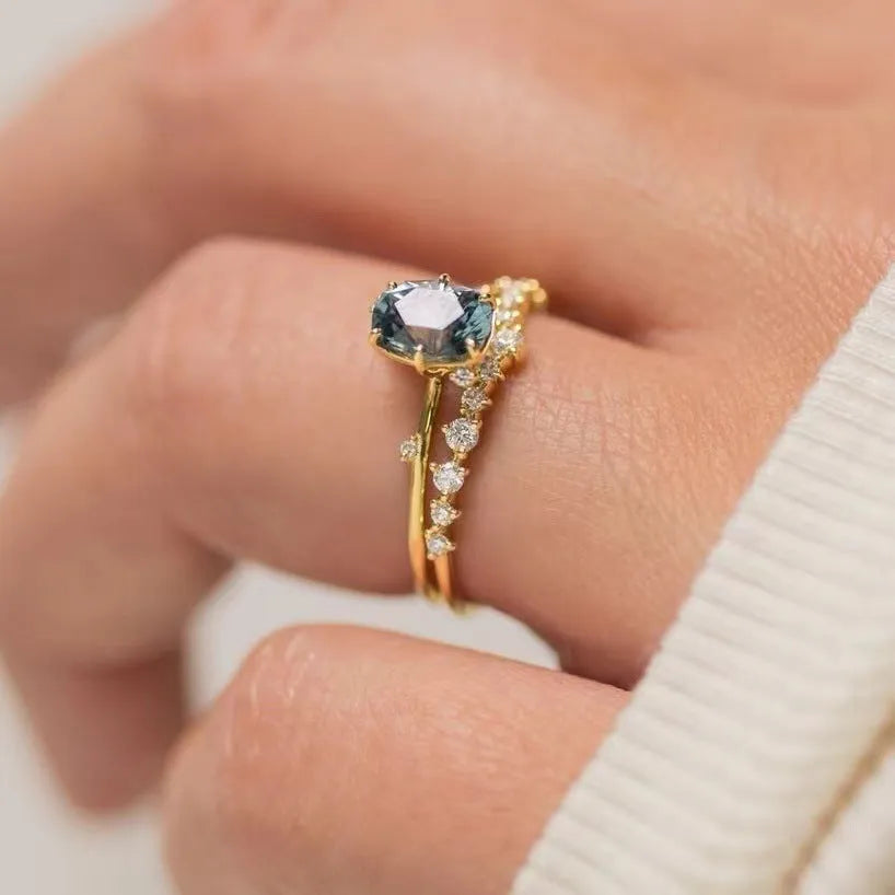 Gold plated women's ring with green zircon stone in flower-shaped design on finger