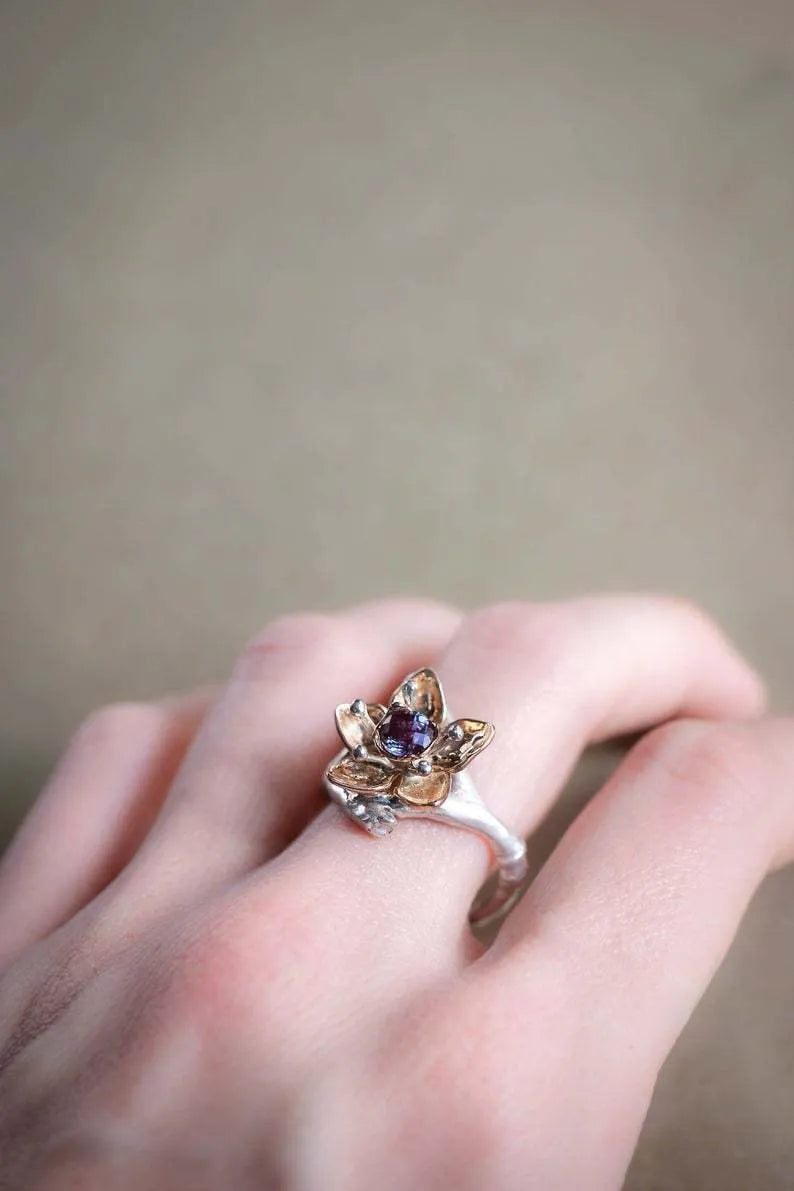 Silver coloured women's alloy ring with geometric shape and two-tone floral design on a white background.