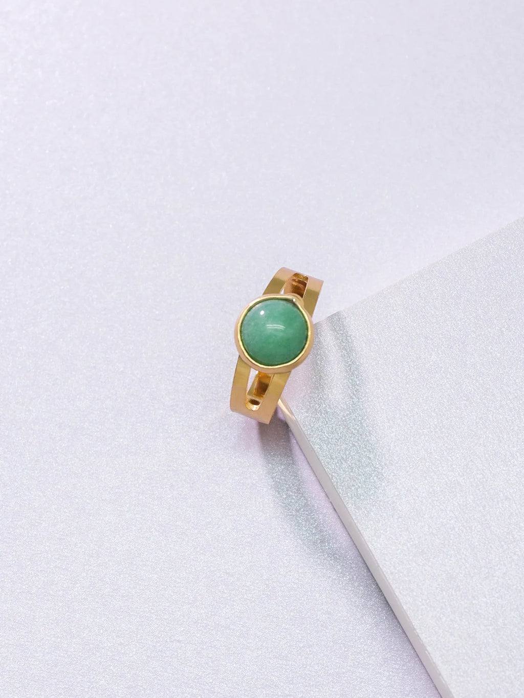 Copper adjustable ring with green natural stone inlay and gold-toned plating on white background