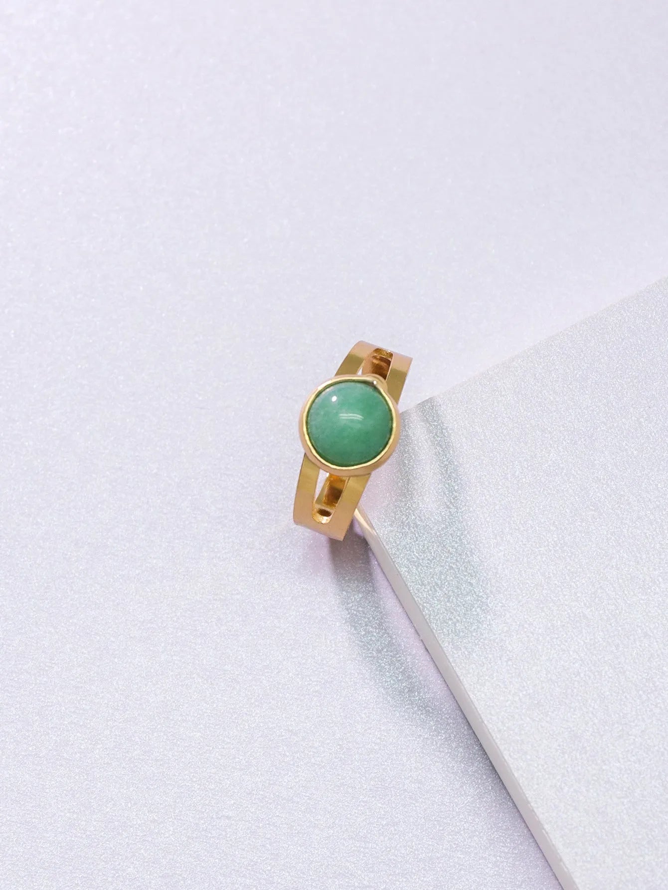 Copper adjustable ring with green natural stone inlay and gold-toned plating on white background