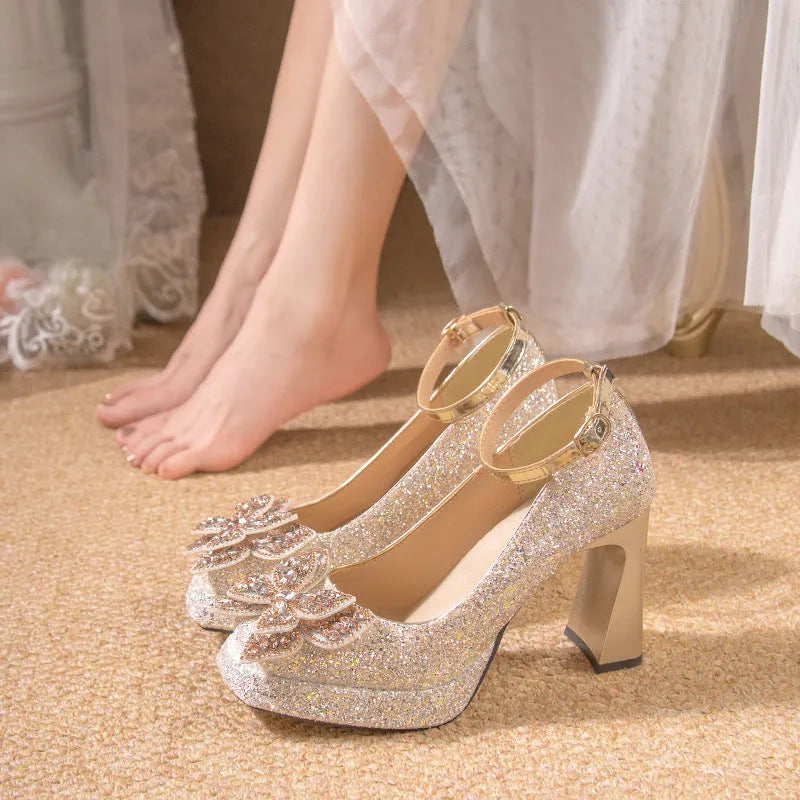 Women's crystal sequined high heels in silver with short stout heel and buckle fastening on a white background
