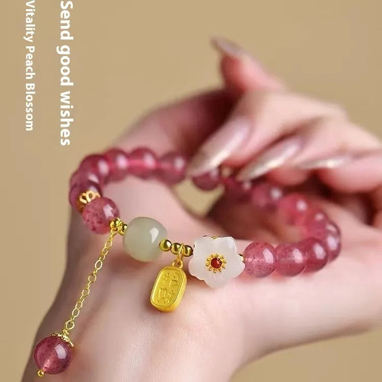 Handmade women's bracelet with strawberry quartz beads and Hetian jade peach blossom details.