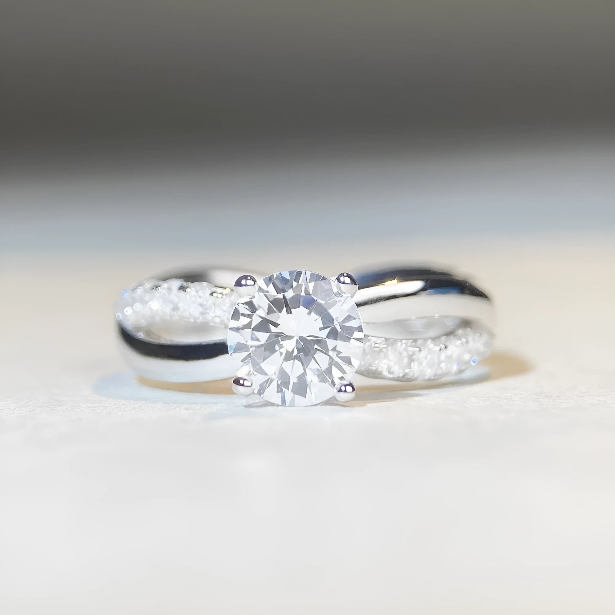 Silver geometric twist band ring with a 1-carat Moissanite stone in a four-claw setting.