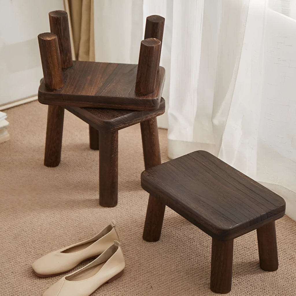 Solid wood shoe changing stool with a distressed rustic finish and sturdy bracket legs.
