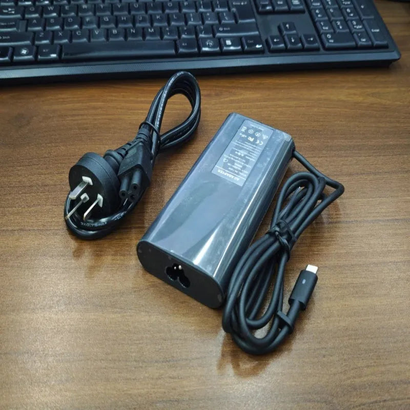 Black 65W USB-C laptop power adapter with set of international plug cords.
