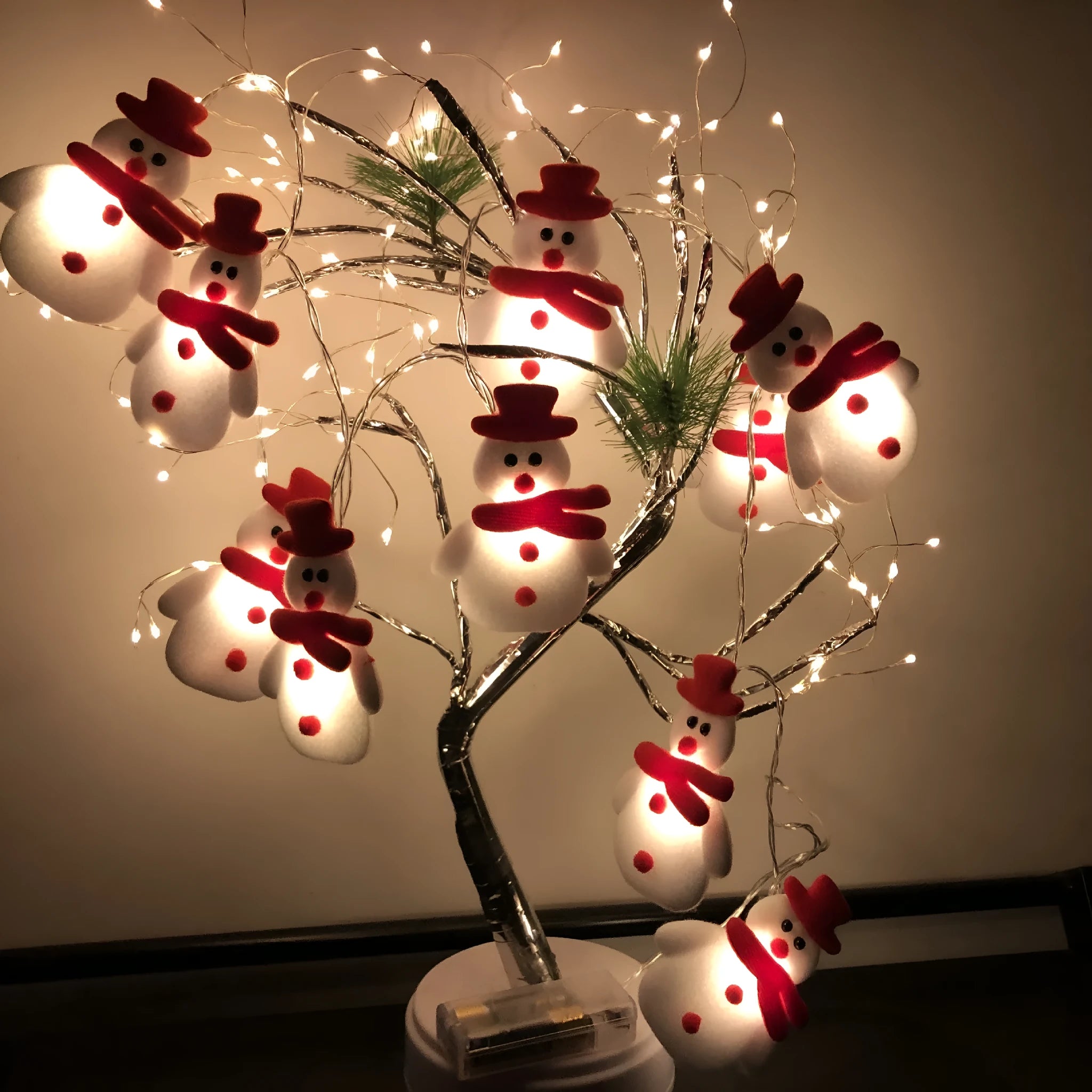 Warm white LED Christmas string lights with Snowman decorative figures on a green garland.