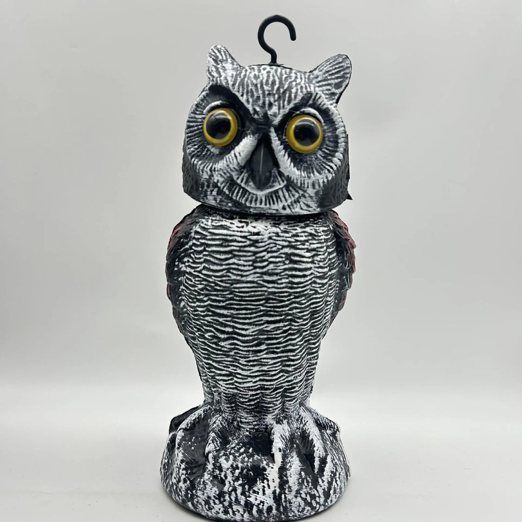 Artificial owl bird scarer decoy with shaking head motion in outdoor setting