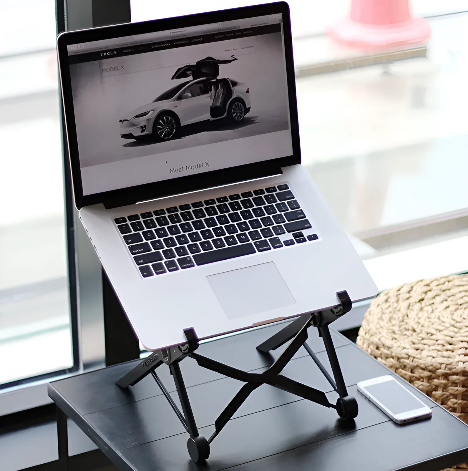 Black folding portable laptop computer stand made from reinforced nylon, shown in both folded and open positions.