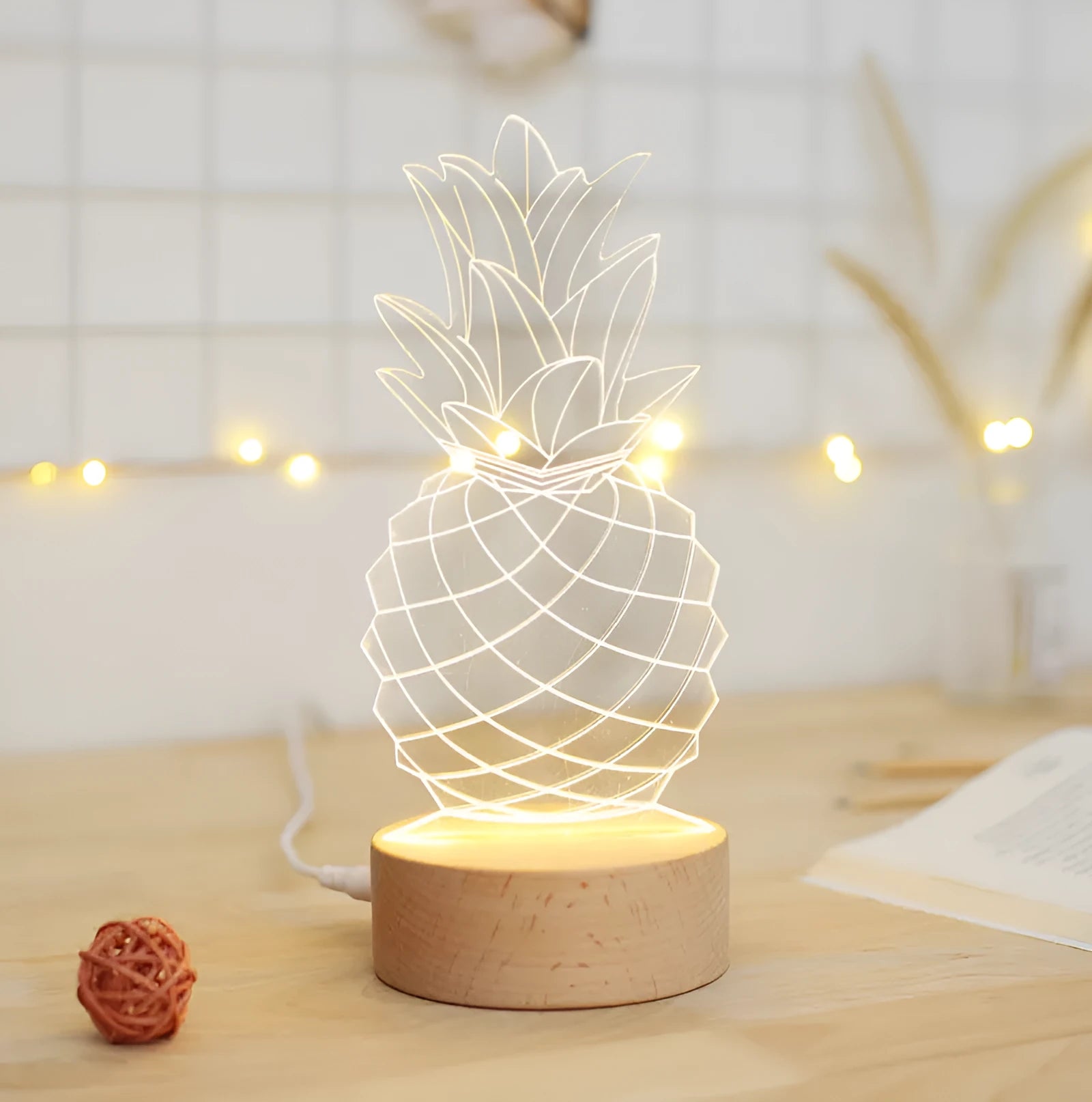 Wood and acrylic dimmable pineapple-shaped USB night light on a table.