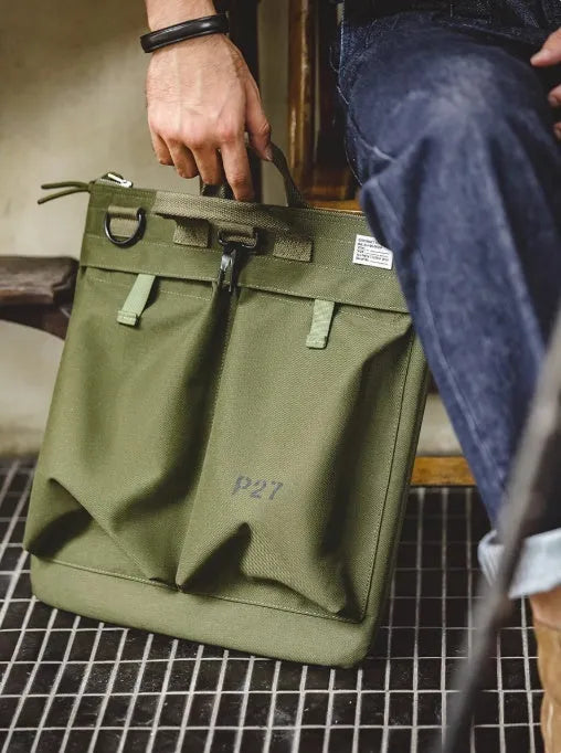 Medium canvas crossbody messenger bag in military green showing laptop compartment and shoulder strap