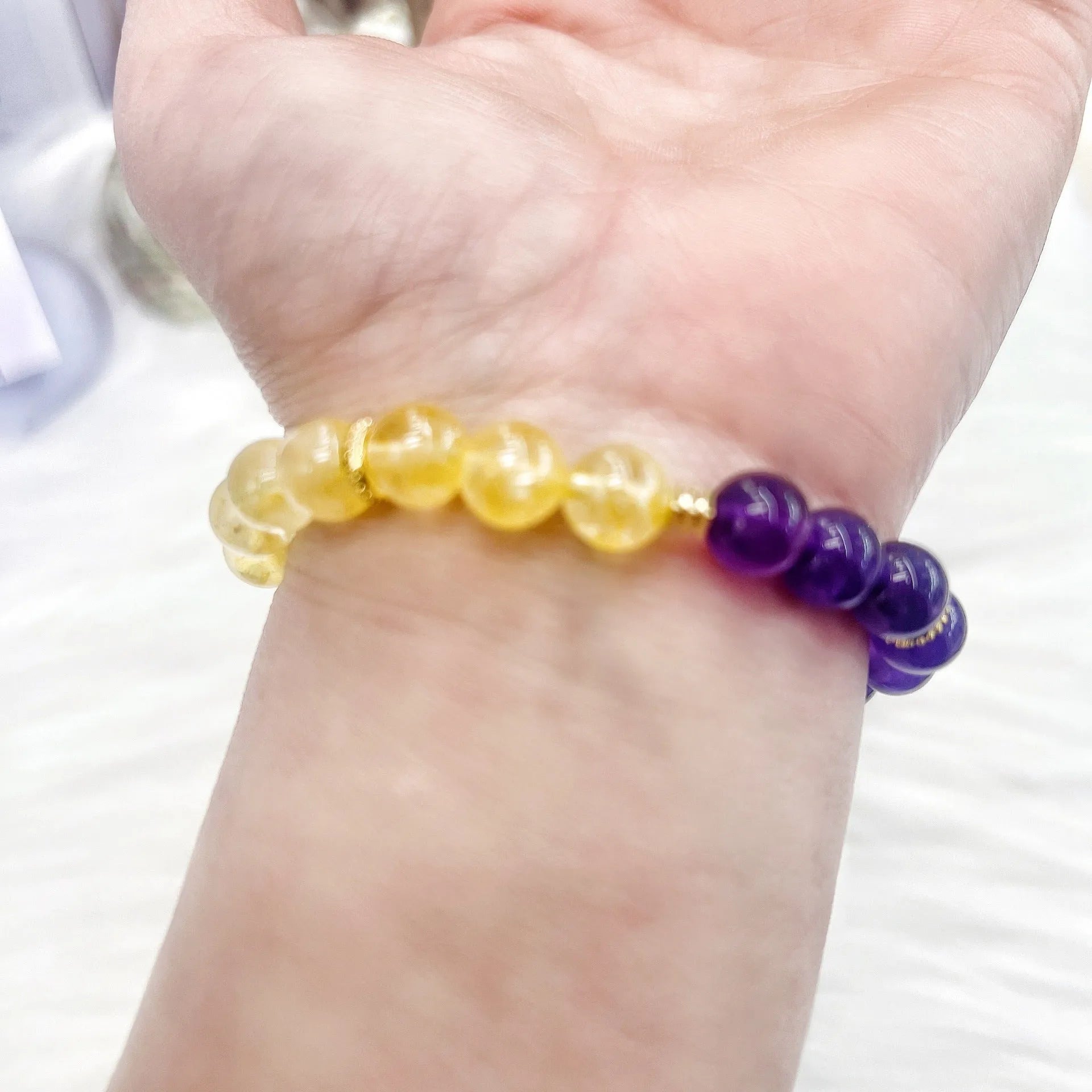 Handmade women's yellow and purple amethyst crystal bracelet on wrist