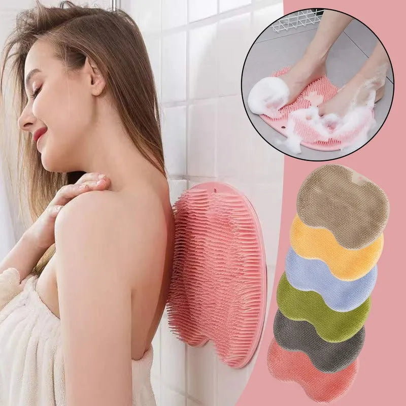 Orange TPR bath brush with silicone bristles and suction cups on base, shown on bathroom tiles.