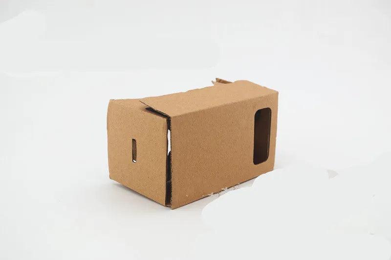 Pink and white cardboard VR glasses for smartphones, shown with 3D lenses and a rubber headband.