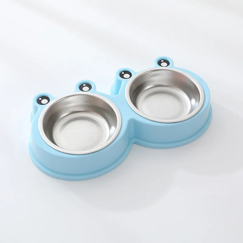 Frog-shaped plastic holder containing two stainless steel pet bowls for food and water.