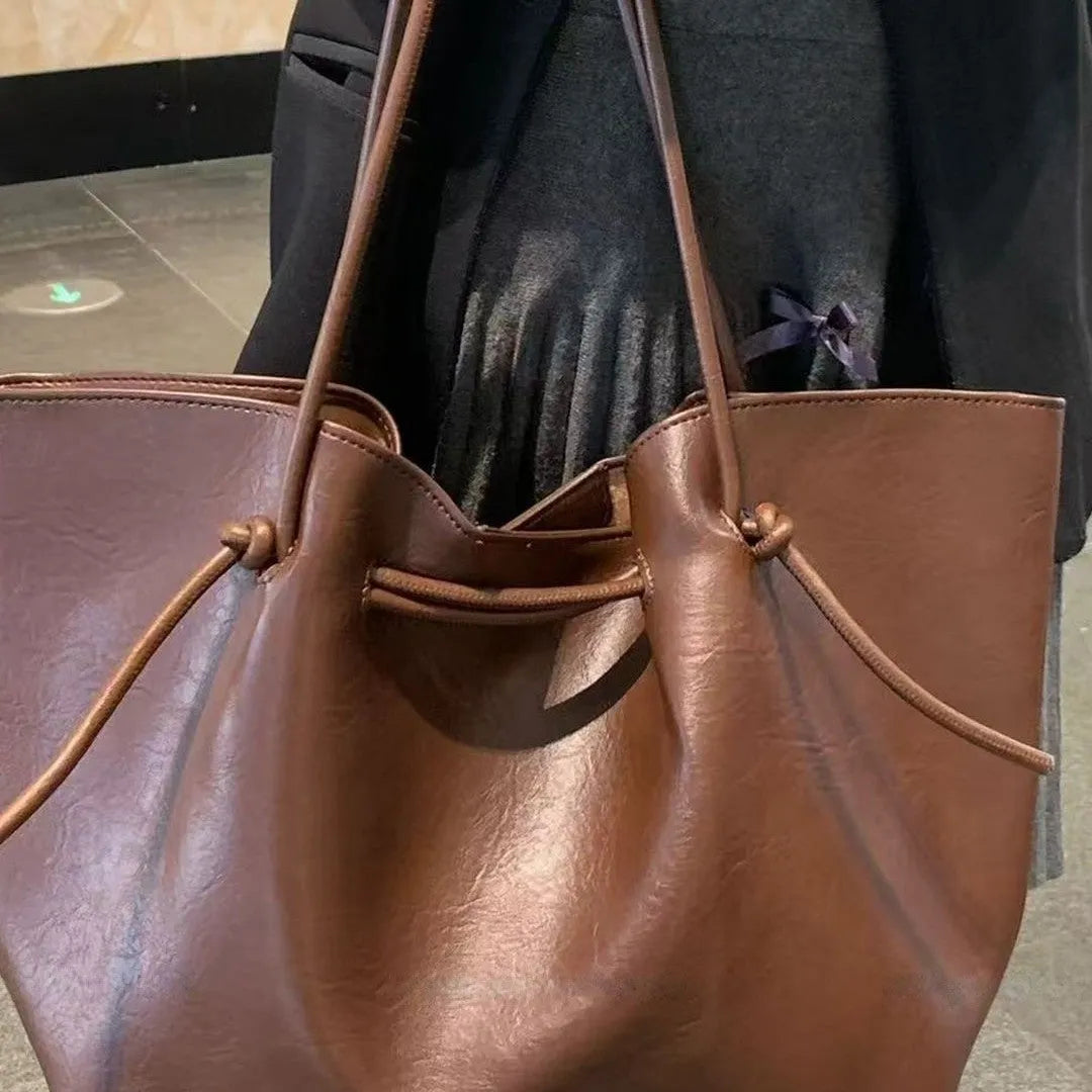 Black PU leather commuter bag with double shoulder straps and solid colour finish, front view