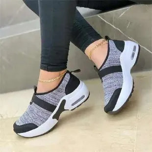 Women's white mesh flat sneakers with round toe and colour stitching on a rubber sole.